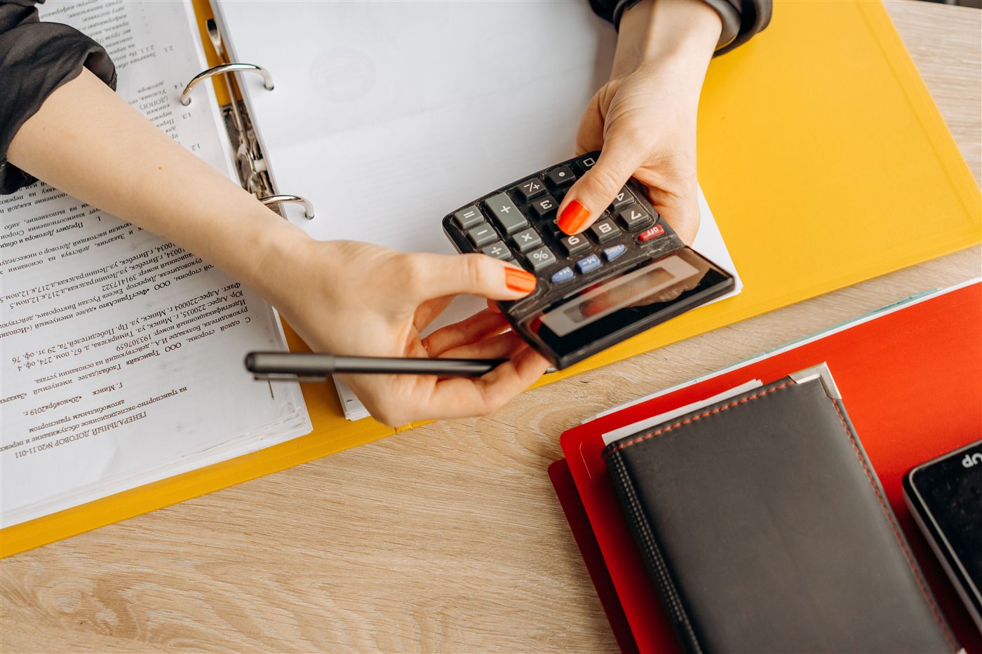 A calculator and financial ledgers on a desk