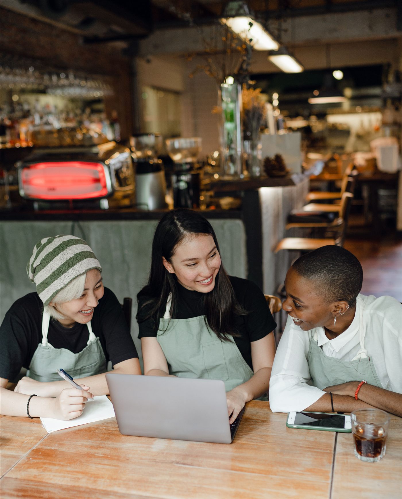 Restaurant staff reviewing a laptop together at the counter